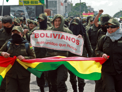 Police officers, who have joined a rebellion, take part in a march to protest against Bolivian President Evo Morales with a sign reading "Bolivians more united than ever" in Santa Cruz, Bolivia, on November 9, 2019. - Police in three Bolivian cities joined anti-government protests Friday, in one case marching …