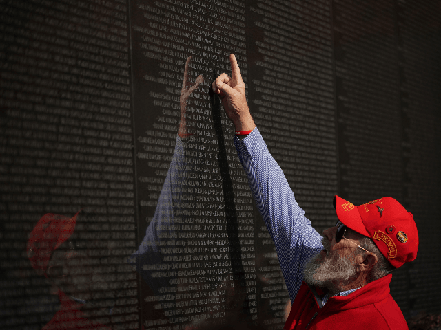A veteran points to a name on the Vietnam War Memorial on Veterans Day on November 11, 201