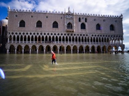 A general view shows a person walking across the flooded St. Mark's Square by the Doge's palace on November 14, 2019 in Venice. - Much of Venice was left under water after the highest tide in 50 years ripped through the historic Italian city, beaching gondolas, trashing hotels and sending …