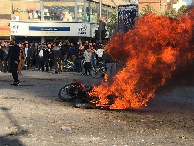 Iranian protesters gather around a burning motorcycle during a demonstration against an increase in gasoline prices in the central city of Isfahan, on November 16, 2019. - One person was killed and others injured in protests across Iran, hours after a surprise decision to increase petrol prices by 50 percent …