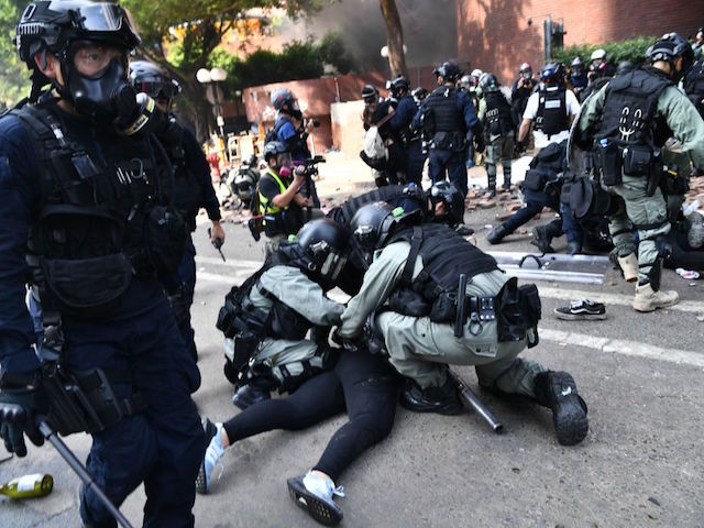 Protesters are detained by police near the Hong Kong Polytechnic University in Hung Hom district of Hong Kong on November 18, 2019. - Pro-democracy demonstrators holed up in a Hong Kong university campus set the main entrance ablaze on November 18 to prevent surrounding police moving in, after officers warned they may use live rounds if confronted by deadly weapons. (Photo by Anthony WALLACE / AFP) (Photo by ANTHONY WALLACE/AFP via Getty Images)
