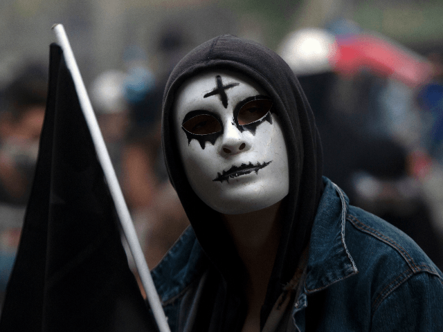 A demonstrator takes part in a protest against the government in Santiago on November 18, 2019. - President Sebastian Pinera condemned on Sunday for the first time what he called abuses committed by police in dealing with four weeks of violent unrest that have rocked Chile and which has left …