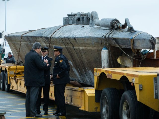 Official stand near a submarine used to transport drugs illegally in Aldan, northwestern S