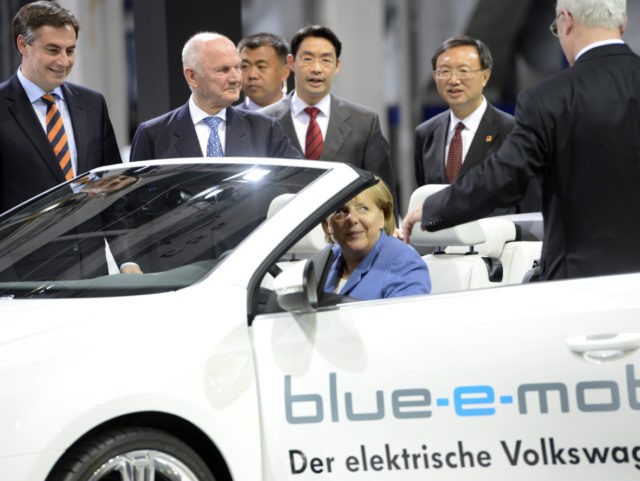 Volkswagen chairman Martin Winterkorn (R) and Chancellor Angela Merkel inspect an electric car during a visit to the Volkswagen plant in Wolfsburg, central Germany, on April 23, 2012. German car maker Volkswagen is expected to ink contracts for a new plant in Xinjiang, northwest China. AFP PHOTO / ODD ANDERSEN …