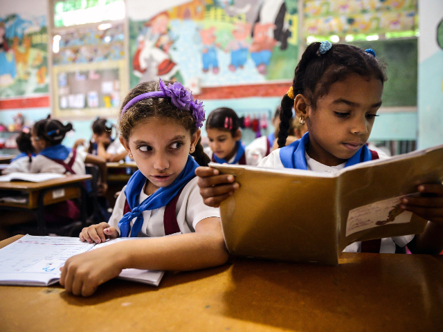 Cuban schoolgirls read during class, on November 13, 2012, in Havana. AFP PHOTO (Photo cre