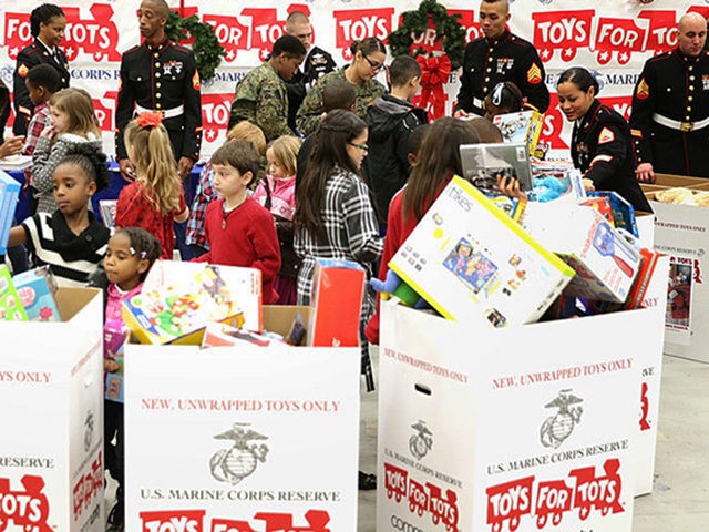 WASHINGTON, DC - DECEMBER 19: U.S. first lady Michelle Obama (L) helps children to sort gifts for the Marine Corps' Toys for Tots Campaign December 19, 2013 at Joint Base Anacostia-Bolling in Washington, DC. The first lady delivered toys and gifts donated to the campaign during the event and visited …