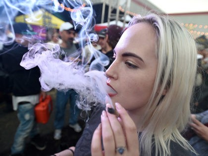 A woman from Seattle, smokes a joint at the first annual DOPE Cup, a cannabis competition in Portland, Oregon, on October 4, 2015. As of October 1, 2015 limited amounts of recreational marijuana became legal for all adults over the age of 21 to purchase in the state of Oregon. …