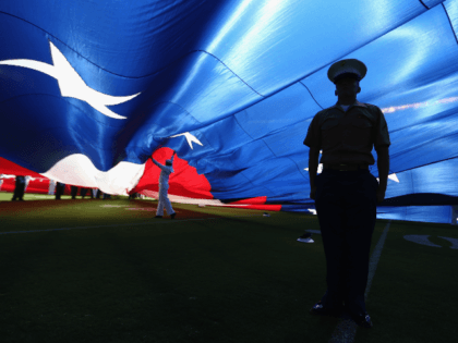 A U.S. Marine stands at attention under a large American flag before a game between the Jacksonville Jaguars and the San Diego Chargers at Qualcomm Stadium on September 18, 2016 in San Diego, California. (Photo by Sean M. Haffey/Getty Images)