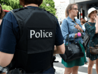 TOPSHOT - A police officer speaks with parents of children at a nearby high school in the eastern Belgian city of Liege on May 29, 2018, after a gunman killed two female police officers and a man in a parked car before he was shot dead by police. - The …