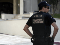 A police officer stands in front of the house of Greek journalist Socratis Guiolas, after the latter was killed, on July 19, 2010 in Athens. Gunmen shot and killed Guiolas, early Monday in front of his home near Athens, before fleeing in a car, police said. At least three unknown …