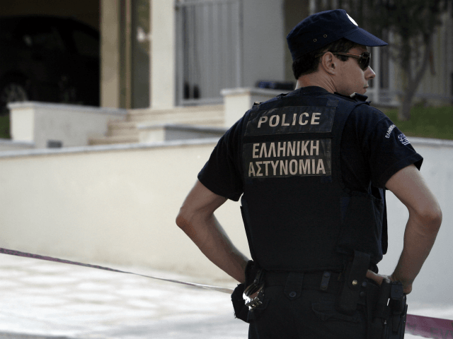A police officer stands in front of the house of Greek journalist Socratis Guiolas, after