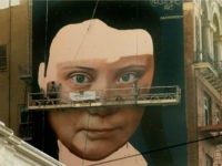 Andres Petreselli paints a mural on the side of a building depicting Swedish teen climate activist Greta Thunberg, Friday, Nov. 8, 2019, in San Francisco. (AP Photo/Ben Margot)