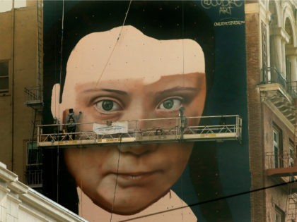 Andres Petreselli paints a mural on the side of a building depicting Swedish teen climate activist Greta Thunberg, Friday, Nov. 8, 2019, in San Francisco. (AP Photo/Ben Margot)