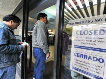 People wait in line to get into a California Department of Motor Vehicles office in Los Angeles in February 2009. The DMV is training 900 newly hired employees in anticipation of a crush of applications this January, when immigrants without legal status may begin applying for a special driver's license …