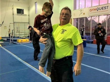 Plainfield Fire Chief Jon Stratton holds birthday boy Dominic Giatras — and his Nerf gun — aloft. A Nerf gun fight was one of several games Plainfield firefighters played with Dominic and other children at GymQuest over the weekend. (Plainfield Fire Department)