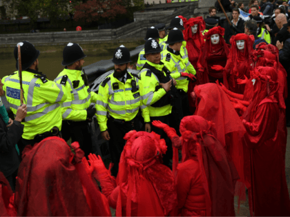LONDON, ENGLAND - OCTOBER 07: The Red Brigade of The Invisible Circus gesture to police in Westminster on October 7, 2019 in London, England. Climate change activists are gathering to block access to various government departments as they start a two week protest in central London (Photo by Chris J …