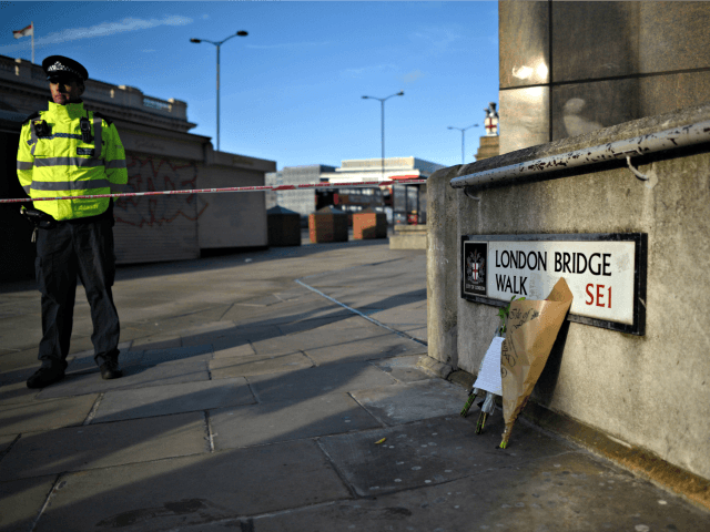 LONDON, ENGLAND - NOVEMBER 30: Flowers rest against a wall at the scene of yesterday'