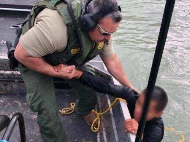 A Laredo Sector Marine Unit agents pulls a Mexican migrant from a creek near the Rio Grand