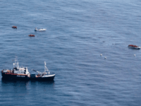 In this photo taken on Saturday, Oct. 26, 2019, The Alan Kurdi rescue ship, foreground, approaches a dinghy boat full of migrants, top right, as a Libya-flagged speedboat, top left, sails around, off the coast of Libya. A humanitarian aid group said gunmen on Libya-flagged speedboats threatened the crew of …