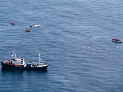In this photo taken on Saturday, Oct. 26, 2019, The Alan Kurdi rescue ship, foreground, approaches a dinghy boat full of migrants, top right, as a Libya-flagged speedboat, top left, sails around, off the coast of Libya. A humanitarian aid group said gunmen on Libya-flagged speedboats threatened the crew of …