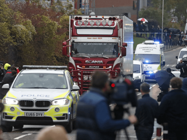 Police escort the truck, that was found to contain a large number of dead bodies, as they