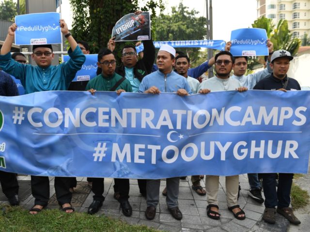 People take part in an event in front of the Chinese embassy in Kuala Lumpur on July 5, 20