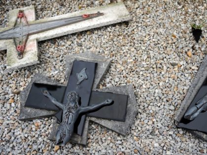 A photo taken on April 15, 2015 shows a broken crucifix on the ground after tombstones were found vandalized at the Saint-Roch cemetery in Castres, southern France. French President Francois Hollande condemned "in the strongest terms" the vandalism of "dozens of Christian tombs" at the Saint-Roch cemetery, qualifying the acts …
