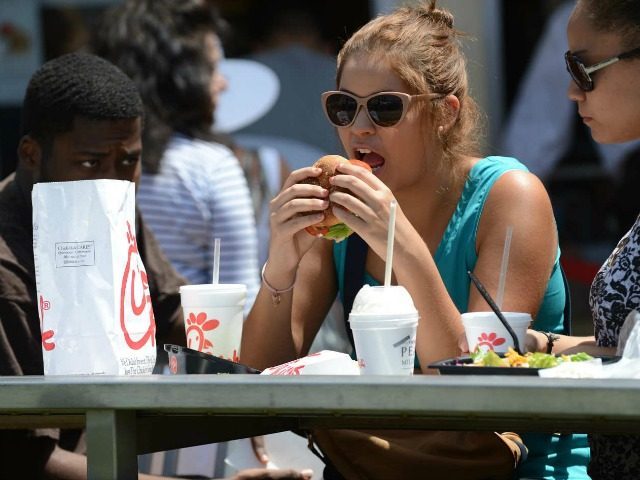 A woman eats lunch on the patio of the Chick-fil-A in Hollywood, California, August 1, 2012. Thousands of Americans turned out Wednesday to feast on fried chicken in a politically-charged show of support for a family owned fast-food chain which opposes same-sex marriage. Long lines and traffic jams were reported …