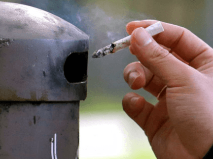 In this Oct. 27, 2015, file photo, a University of Washington student discards a cigarette into a container at a designated smoking locations on the campus in Seattle. Seventeen public health schools in the U.S. and Canada have pledged to refuse research money from a new anti-smoking group funded by …