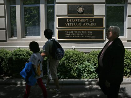 Pedestrians walk in front of the Department of Veterans Affairs building in Washington, Fr