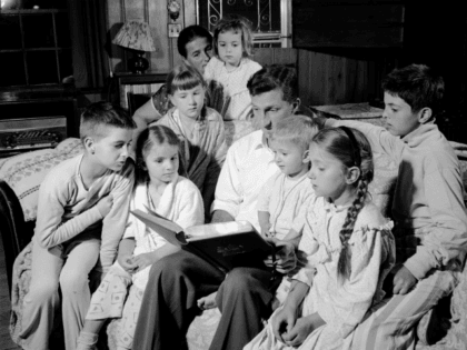 circa 1956: A whole family gathered in the evening for readings of their favourite Bible stories. (Photo by Sherman/Three Lions/Getty Images)