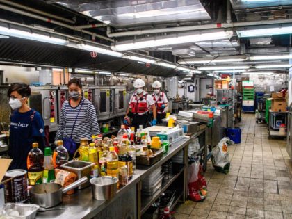 A team including Poly U management, security guards, councillors and the Hong Kong Red Cross walk through a canteen kitchen in search of any remaining protesters hiding at the Hong Kong Polytechnic University in the Hung Hom district of Hong Kong on November 26, 2019, over a week after police …