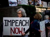 A demonstrator with a sign reading "Impeach now" takes part in Trumps Birthday Protest in front of the Trump International Tower, June 14, 2019 in New York City. - A group of activists protested against his immigration policy. (Photo by Johannes EISELE / AFP) (Photo credit should read JOHANNES EISELE/AFP …