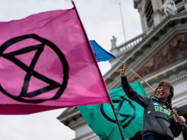 An activist from the climate change action group Extinction Rebellion holds a flag during