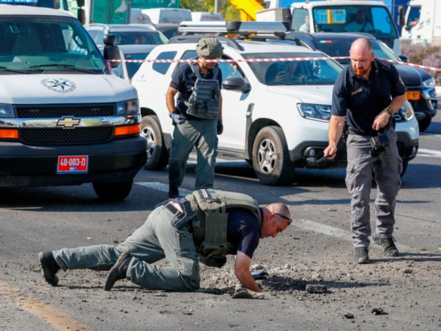 Israeli police sappers inspect a hole in the highway in the southern Israeli city of Ashdod on November 12, 2019, following a rocket attack from Gaza City in retaliation to the Israeli strike that killed a commander of Palestinian militant group Islamic Jihad. - Israel's military killed a commander of …