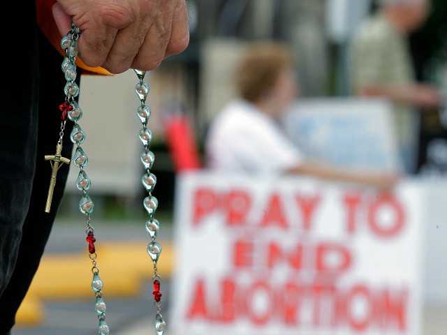 Phil Thiltrickett, an opponent of an abortion, holds a rosary as he prays outside a Planned Parenthood Clinic, Tuesday, Oct. 29, 2013, in San Antonio. A federal appeals court judge is considering whether to grant an emergency appeal that would allow the state to enforce a law that could shut down a dozen abortion clinics in Texas. In court papers filed with the 5th Circuit Court of Appeals, Texas Attorney General Greg Abbott asked the judge to make a decision by the end of the day Tuesday. (AP Photo/Eric Gay)