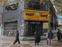 Iranians gather outside a post office branch that was damaged during demonstrations against petrol price hikes, on November 20, 2019 in Shahriar, west of Tehran. - Three security personnel have been killed by "rioters" in Iran, the latest deaths in protests that showed no sign of subsiding today despite a …