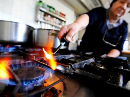 An Austrian hotel owner lights a gas stove to cook for customers in Puch bei Hallein on Ja