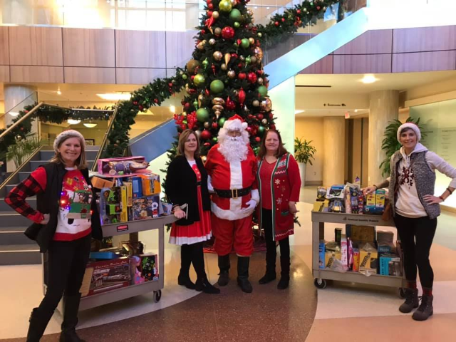 Members of Braylonstrong, a brain tumor foundation, pose before passing out toys on Sunday