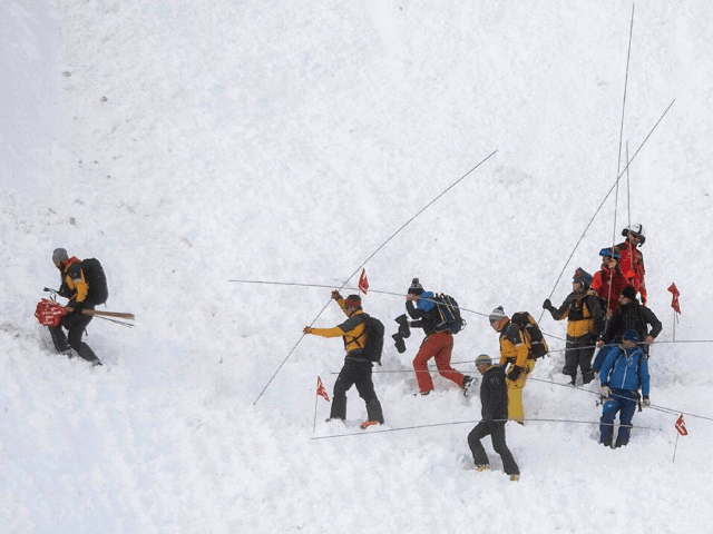 Rescue forces search for missing people after an avalanche swept down a ski piste in the c