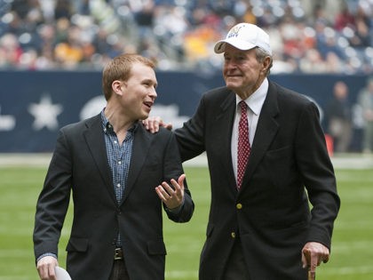 Former United States president George H. W. Bush, right, leaves the field with the help of Pierce Bush, his grandson, before the Texas Bowl NCAA college football game Thursday, Dec. 31, 2009 in Houston. (AP Photo/Dave Einsel)