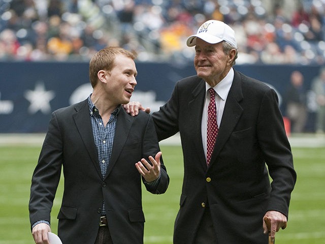 Former United States president George H. W. Bush, right, leaves the field with the help of