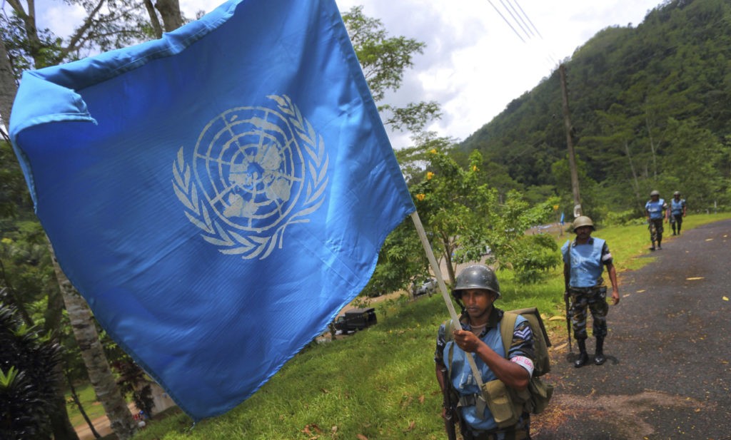 FILE - In this Sept. 13, 2016 photo, a Sri Lanka Air Force airman carries the U.N. flag during training for a road patrol at the Institute of Peace Support Operations Training in Kukuleganga, Sri Lanka. A U.N. fund to help victims of sexual abuse and exploitation by peacekeepers and U.N. staff has now grown to $1.5 million following contributions from 10 more countries including Sri Lanka, whose troops were implicated in a three-year-long child sex ring in Haiti. The U.N. Department of Field Support made the announcement Thursday, Sept. 28, 2017 in New York. (AP Photo/Eranga Jayawardena, file)