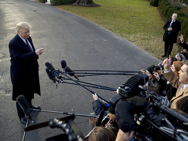 President Donald Trump takes a question from CNN reporter Jim Acosta, right, before boardi