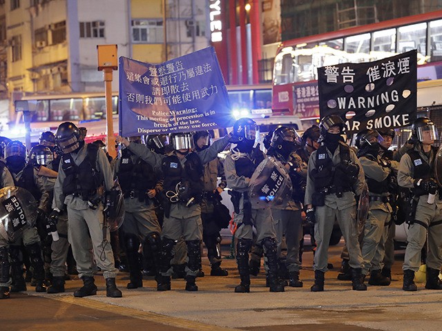 Riot police hold banners warning people not to take out any processions in Hong Kong, Wedn
