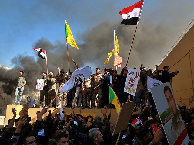 Protesters burn property in front of the U.S. embassy compound, in Baghdad, Iraq, Tuesday, Dec. 31, 2019. Dozens of angry Iraqi Shiite militia supporters broke into the U.S. Embassy compound in Baghdad on Tuesday after smashing a main door and setting fire to a reception area, prompting tear gas and …