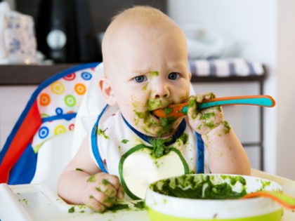 Baby messily eating food