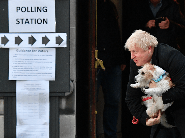 Britain's Prime Minister Boris Johnson poses with his dog Dilyn as he leaves from a Pollin