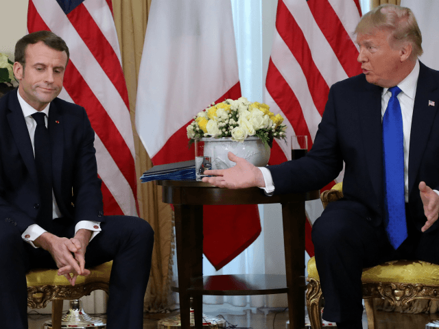US President Donald Trump (R) and France's President Emmanuel Macron react as they talk du