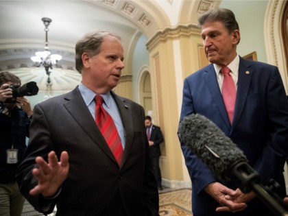 L to R) Sen. Doug Jones (D-AL) and Sen. Joe Manchin (D-WV) speak to reporters after the Senate passed a continuing resolution to fund the federal government, Capitol Hill, January 22, 2018 in Washington, DC. The U.S. Senate has voted to end the shutdown, and Congress will now need to …